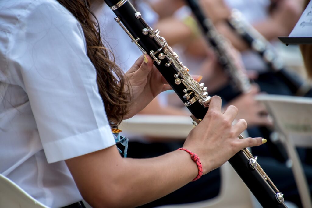 Close-up of a young musician playing a clarinet in an ensemble.
