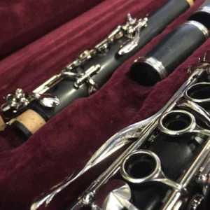 Close-up of clarinet parts in a red velvet case.
