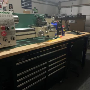 Workshop workbench with a lathe machine and tools.